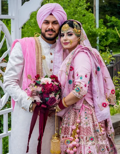 A newlywed Indian couple in a romantic pose against a beautifully decorated backdrop.