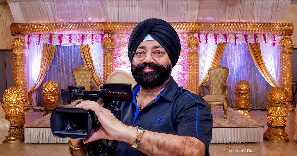 Top Punjabi Wedding Photographers in New York | CandleLight Studio Surinder Singh, lead Punjabi wedding photographer at CandleLight Studio in New York, holding a video camera
